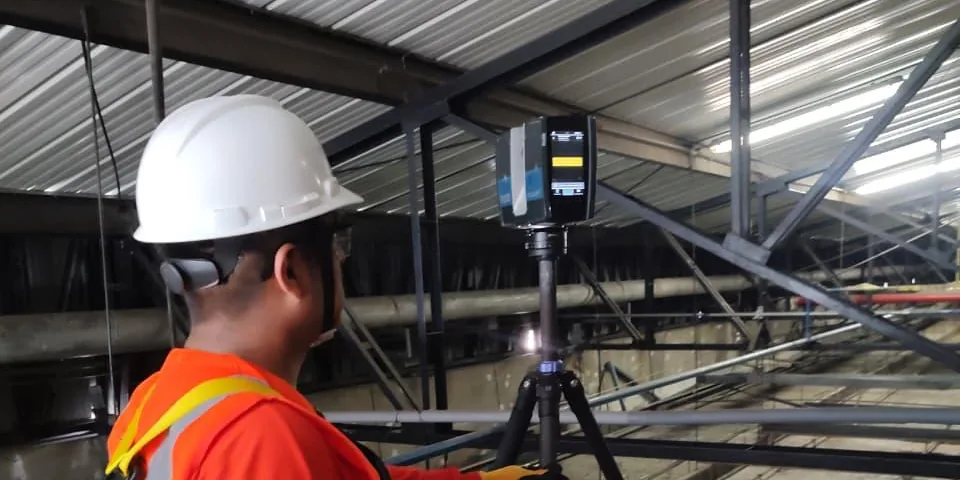Técnico de SAMINS operando un escáner láser 3D sobre trípode en una planta industrial