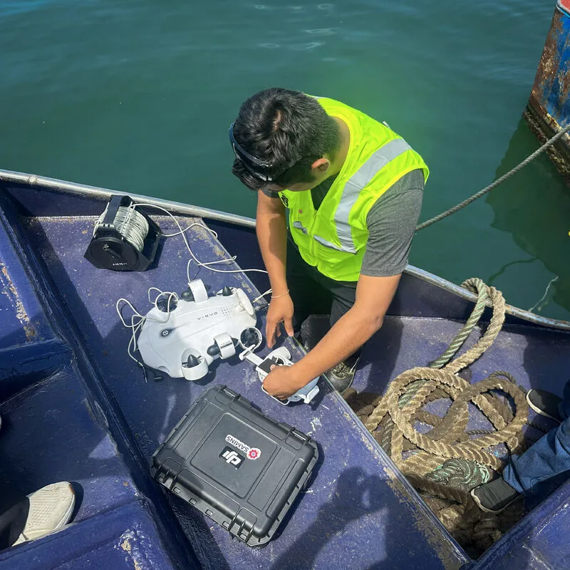 Técnico de SAMINS preparando un dron sobre una lancha para escanear una embarcación